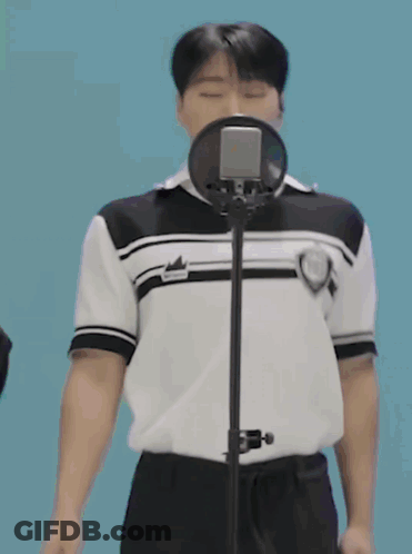 Young Man Singing Into Microphone In Black And White Shirt GIF