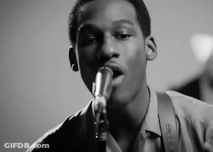Young Man Singing Into Microphone Playing Saxophone GIF