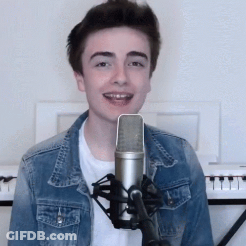 Young Man Singing Into Microphone With Keyboard GIF