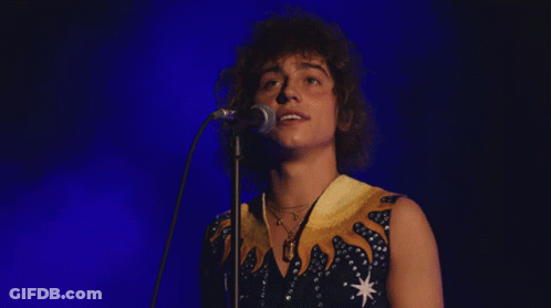 Young Man Singing Into Microphone With Necklace GIF