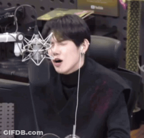 Young Man Sitting At Microphone Eyes Closed GIF