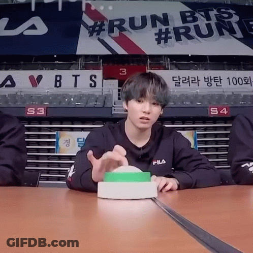 Young Man Sitting At Table With Run BTS Sign GIF