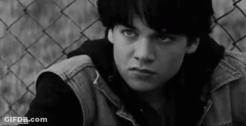 Young Man Sitting By Chain Link Fence GIF