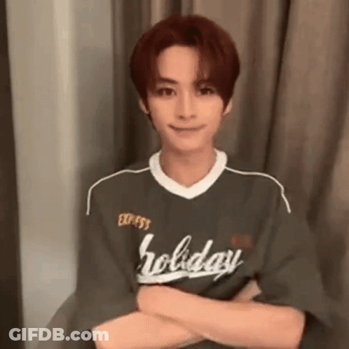 Young Man Sitting In Chair With Arms Crossed Green Shirt GIF