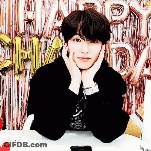 Young Man Sitting In Front Of Happy Day Balloons GIF