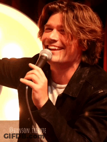 Young Man Smiling Holding Microphone @Hanson Tribute GIF