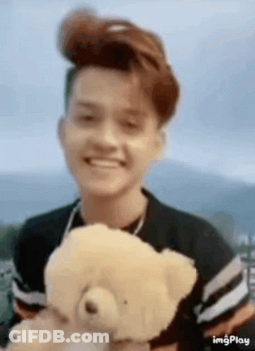 Young Man Smiling Holding Teddy Bear GIF