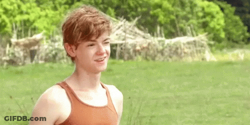 Young Man Smiling In Field In Tank Top GIF