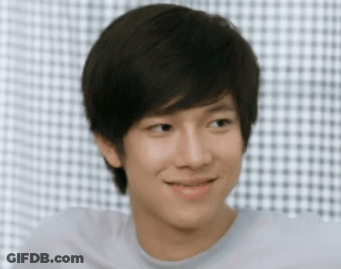 Young Man Smiling In Front Of Checkered Wall GIF