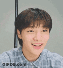 Young Man Smiling In Plaid Shirt GIF