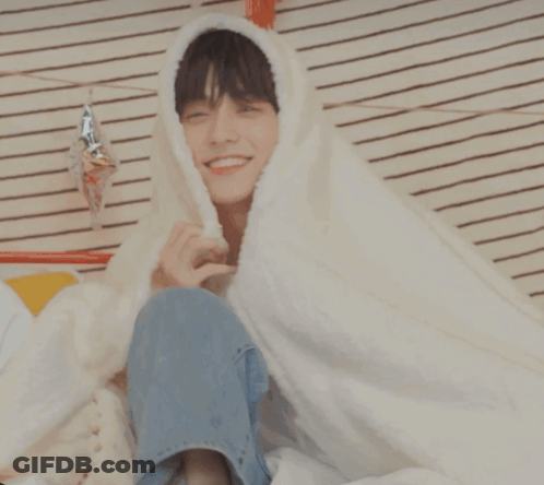 Young Man Smiling In White Blanket GIF