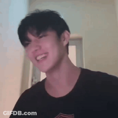 Young Man Smiling Making Funny Face In Black T-Shirt GIF