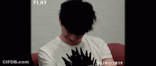 Young Man Smiling On Red Couch GIF