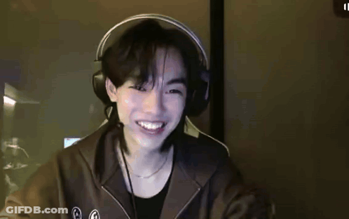 Young Man Smiling With Headphones At Desk GIF
