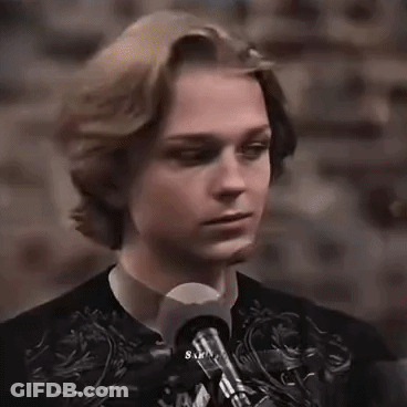 Young Man Standing At Microphone In Dark Room GIF