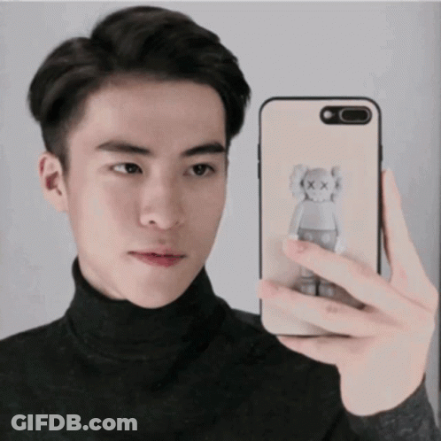 Young Man Taking Selfie With Kaws Bear Phone GIF