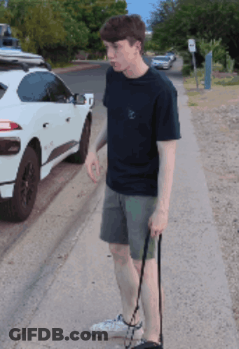 Young Man Walking Dog In Front Of White SUV GIF