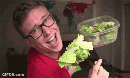 Young Man Wearing Glasses Holding Plastic Container Of Lettuce GIF