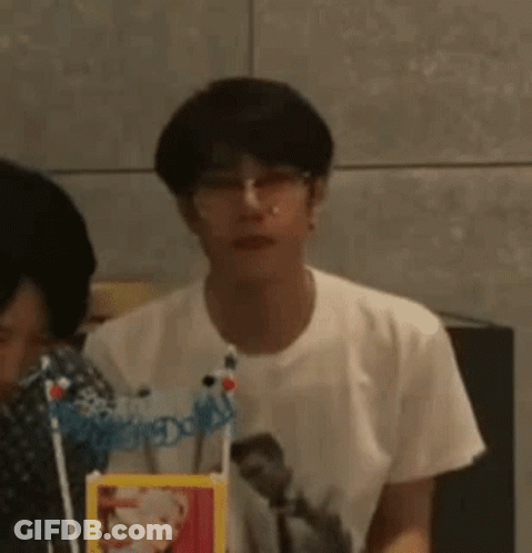 Young Man Wearing Glasses Sitting At Table GIF