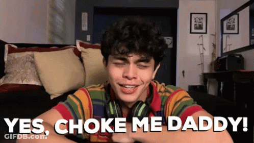 Young Man Wearing Headphones Sitting On Couch Says Yes Choke Me Daddy GIF
