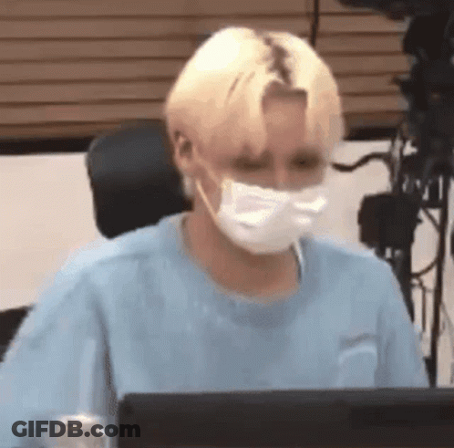 Young Man Wearing Mask Sitting At Computer GIF
