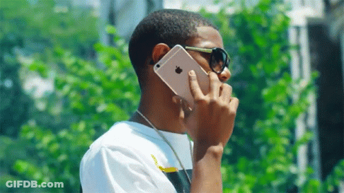 Young Man Wearing Sunglasses Talking On IPhone GIF