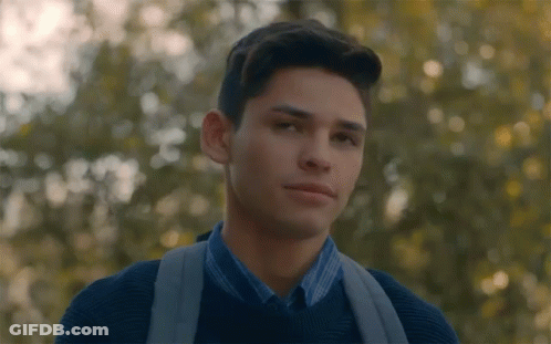 Young Man With Backpack Looking At Camera In Trees GIF