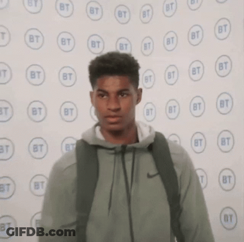 Young Man With Backpack Near BT Logos Wall GIF
