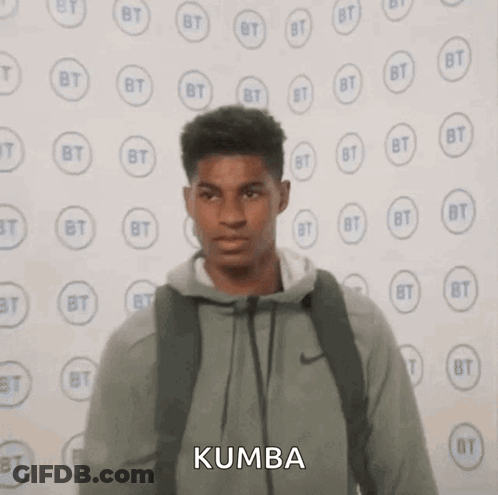 Young Man With Backpack Near Kumba Wall GIF