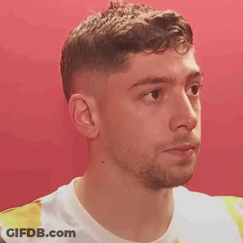 Young Man With Beard In Tie Dye Shirt Looking At Camera GIF