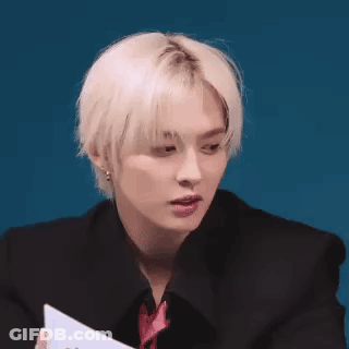 Young Man With Blonde Hair Holding Paper GIF