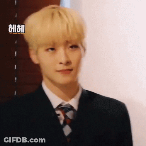 Young Man With Blonde Hair In Suit And Tie Looking At Camera GIF