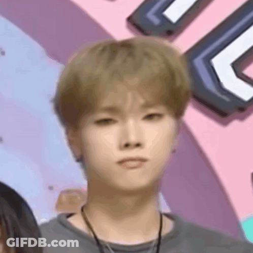 Young Man With Blonde Hair Making Funny Face In Front Of Pink Wall GIF