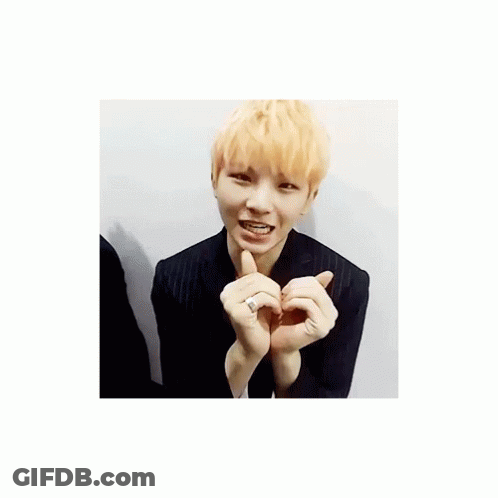 Young Man With Blonde Hair Making Heart With Hands GIF