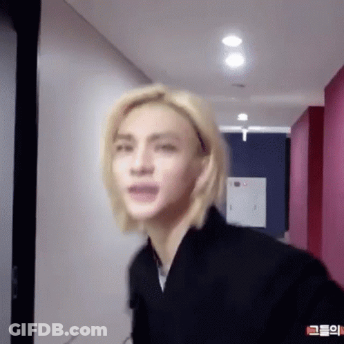 Young Man With Blonde Hair Standing In Hallway GIF