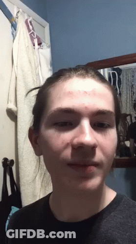 Young Man With Bun Looking At Camera GIF