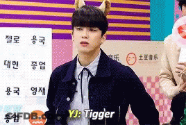Young Man With Cat Ear Headband In Front Of YJ Tigger Sign GIF