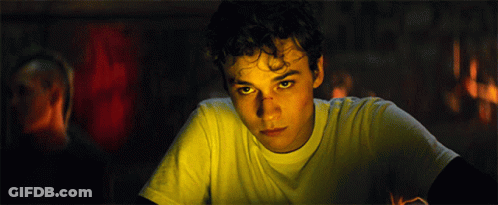 Young Man With Curly Hair And Yellow Eyes Looking At Camera GIF