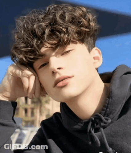 Young Man With Curly Hair In Black Sweatshirt GIF