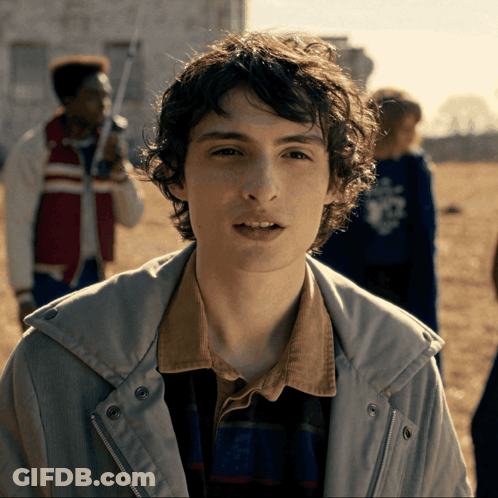 Young Man With Curly Hair In Jacket And Plaid Shirt GIF
