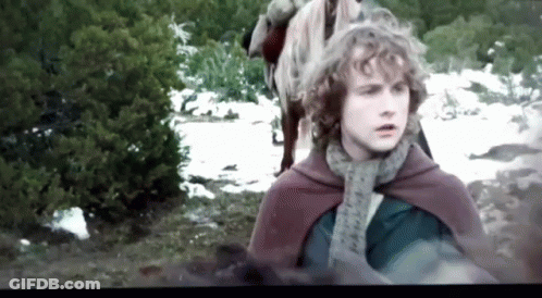 Young Man With Curly Hair In Red Cape And Scarf Standing In Snow GIF