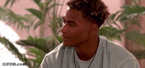 Young Man With Curly Hair In White Sweater And Necklace GIF