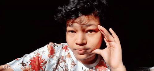 Young Man With Curly Hair Making Funny Face Hand To Ear GIF
