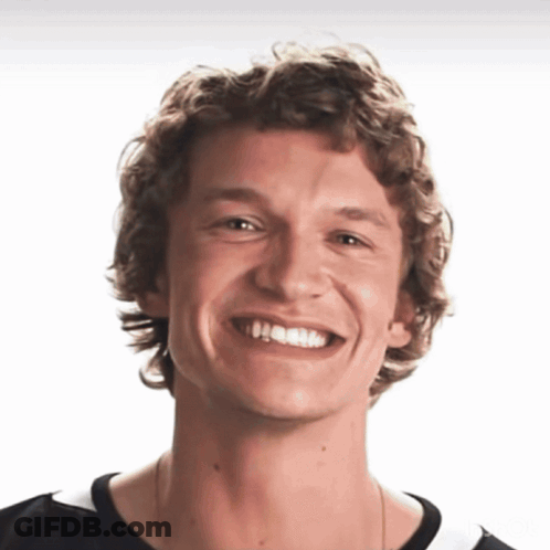 Young Man With Curly Hair Smiling In Black Shirt GIF