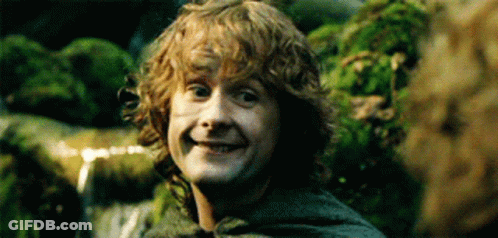 Young Man With Curly Hair Smiling In Front Of Waterfall GIF