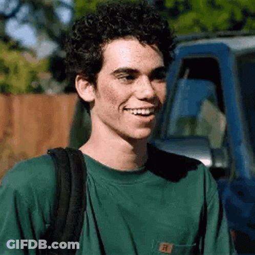 Young Man With Curly Hair Smiling Next To Blue Truck GIF