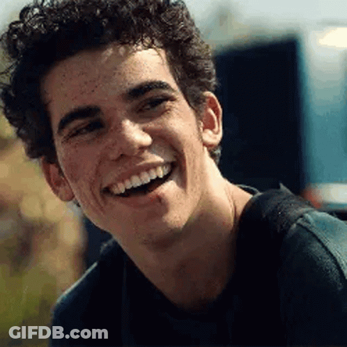 Young Man With Freckles Smiling In Black Shirt GIF