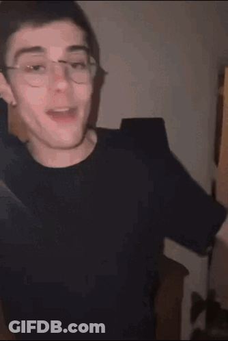Young Man With Glasses In Black Shirt Making Funny Face GIF