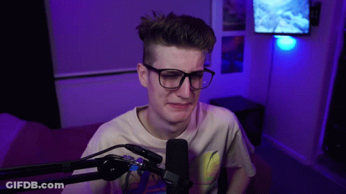 Young Man With Glasses Sitting At Microphone GIF