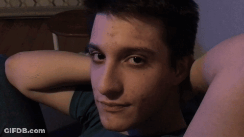 Young Man With Hands Behind Head In Green Shirt GIF